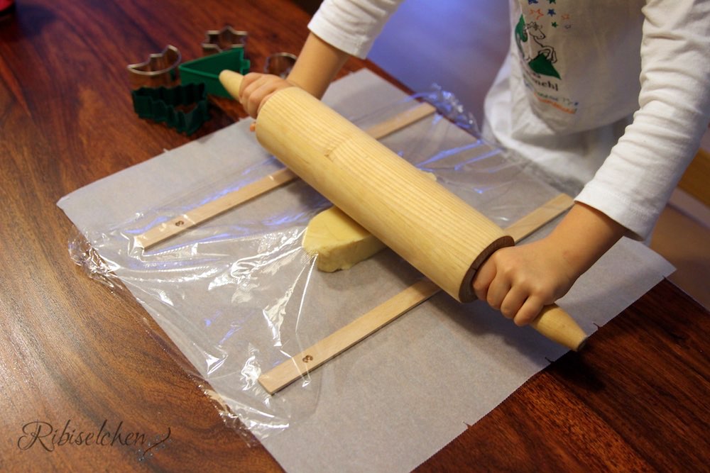 Kind rollt Keksteig aus