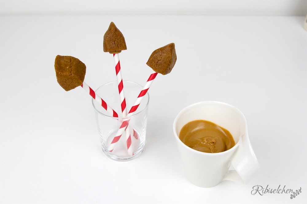 Cake Pops mit Glasur daneben in Tasse 