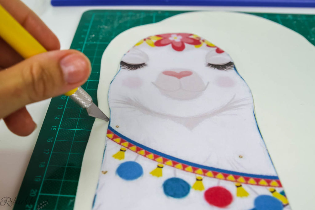 Lama Papiervorlage liegt auf Fondant und wird mit einem Skalpell ausgeschnitten