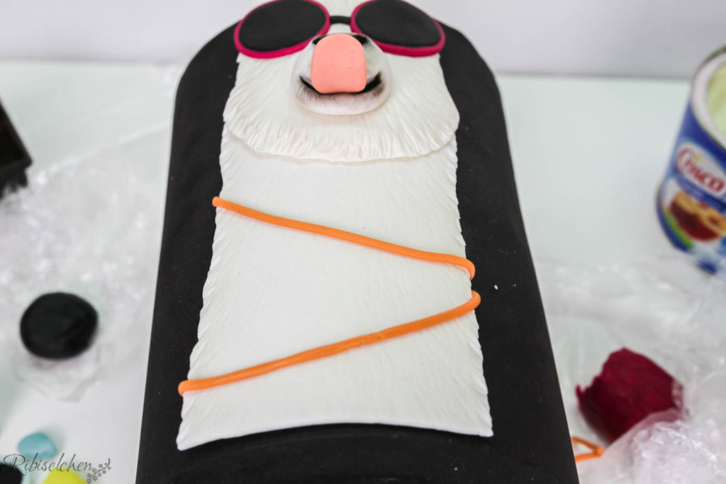 Das Lama aus Fondant liegt zum Trocknen auf einer Styroportorte