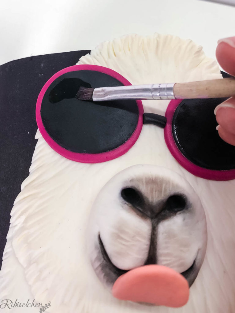 Die Sonnenbrille aus Fondant wird bemalt