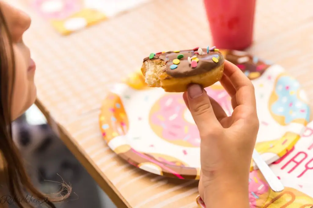 Kind hat einen Donut in der Hand