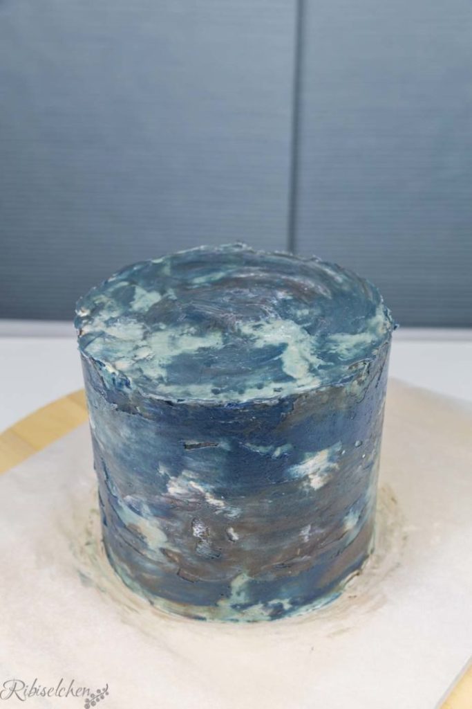 Torte mit einer noch nicht glatten Schicht aus blauer Buttercreme