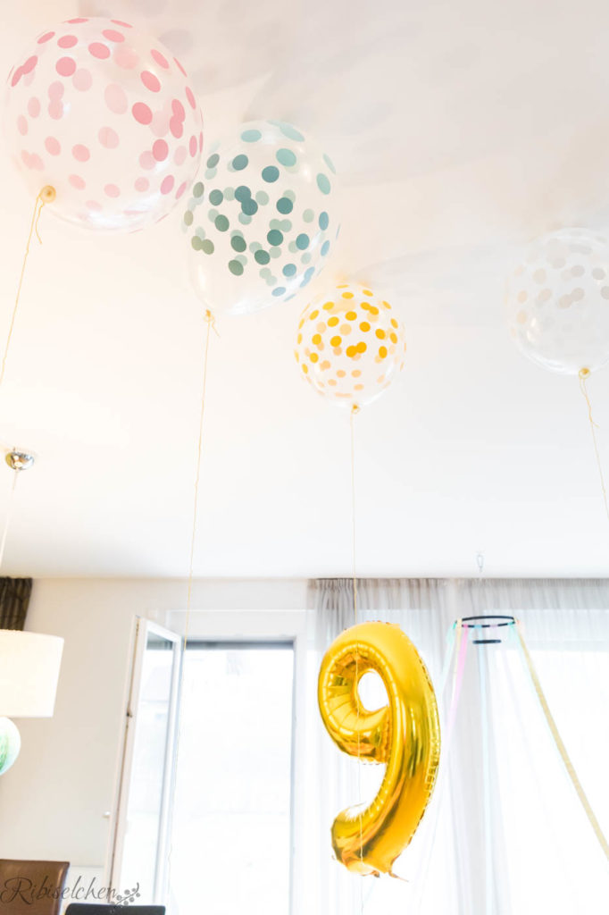 Luftballons mit Punkten schweben an der Decke 