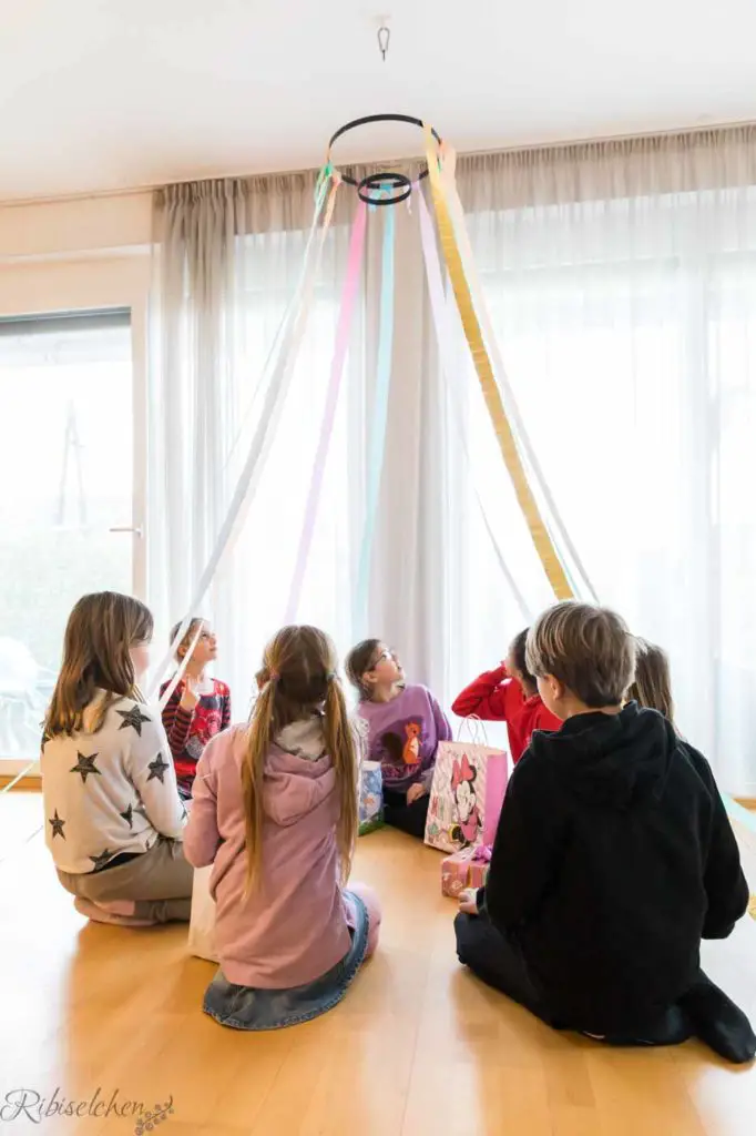 Kinder sitzen im "Zirkuszelt" aus Kreppbändern