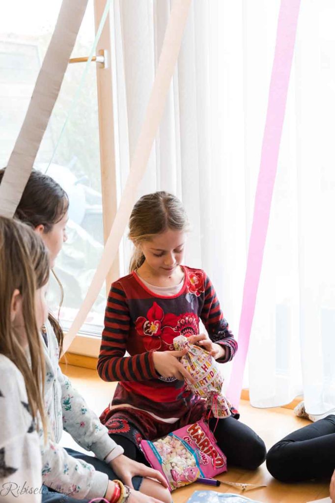 Geburtstagskind packt ein Geschenk aus